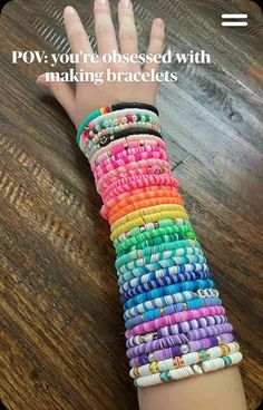 a child's hand holding up a colorful bracelet with the words pov you're obsesed with making bracelets