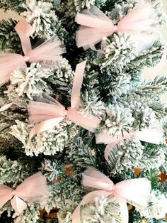 a christmas tree decorated with pink bows and snowflakes