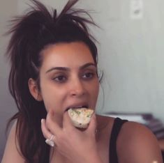 a woman eating food while sitting at a table