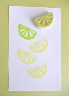 a piece of paper with some cut up lemons on it next to a rubber stamp