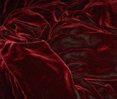 the words never again are written in white on a dark red velvet bed coverlet