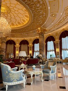 an ornately decorated living room with chandelier and couches in the center