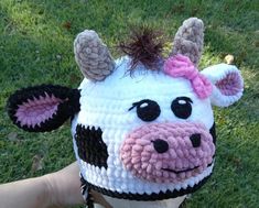 a crocheted cow hat with horns on it's head is being held by someone