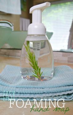 a hand sanitizer sitting on top of a kitchen counter next to a blue towel