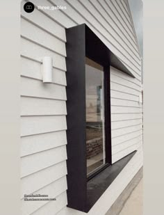 the side of a building with a window and black trim on it's corner