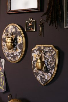 the wall is decorated with two decorative plaques and some key hooks on it's sides