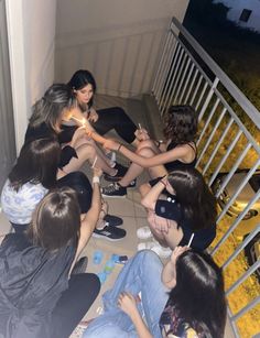 a group of young women sitting on the floor next to each other holding lit candles