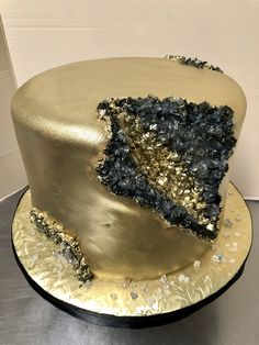 a cake with gold and black frosting on it