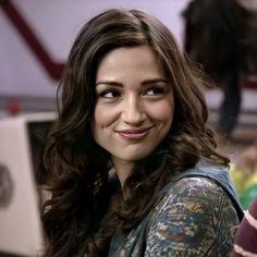 a close up of a person with long dark hair and a smile on her face