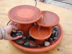 a person is pouring water into a bowl filled with rocks