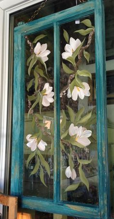 an old window is decorated with flowers and leaves