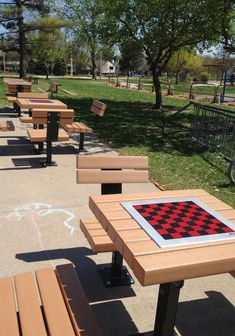 the picnic tables are lined up on the side of the road with checkered squares