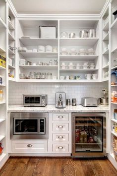 a kitchen with white cabinets and open shelving