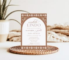 a wedding card is sitting on top of a wicker mat next to a potted plant