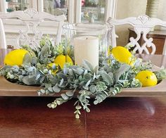 a tray with lemons and greenery sits on a dining room table