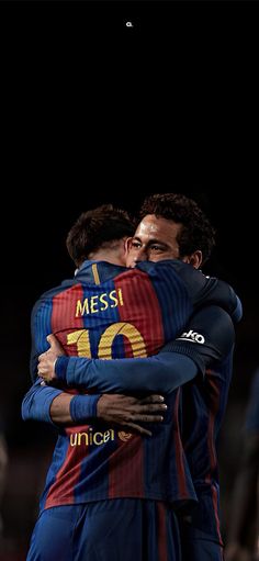 two soccer players hugging each other on the field