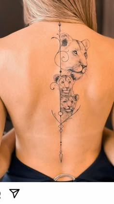 the back of a woman's neck with an arrow and bear tattoo on it