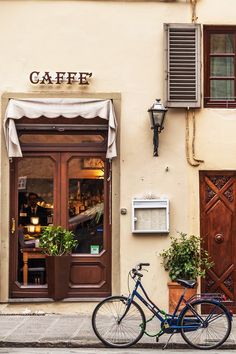 a blue bicycle parked in front of a cafe