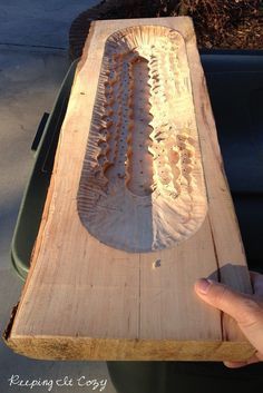 a person holding a piece of wood that has been cut in half and placed on top of it