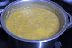 a metal pot filled with soup on top of a stove