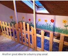 a room with painted flowers on the wall and wooden fenced in area next to it