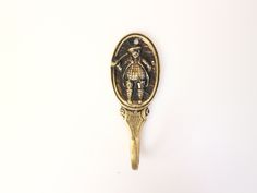 an antique gold and black brooch depicting a man holding a bird on it's back