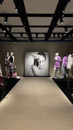 an empty runway with mannequins and clothing on display