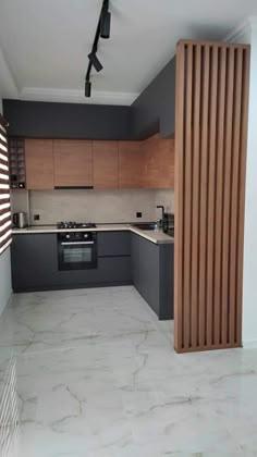 an empty kitchen is shown with wooden slats on the wall and tile flooring