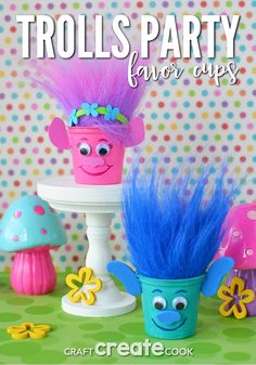 trolls party favors are displayed on a table with colorful flowers and mushrooms in the background