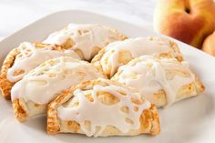 a white plate topped with apple turnovers covered in icing