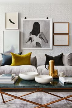 a living room filled with lots of furniture and pictures on the wall above it's coffee table