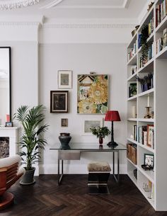 a living room filled with lots of furniture and bookshelves