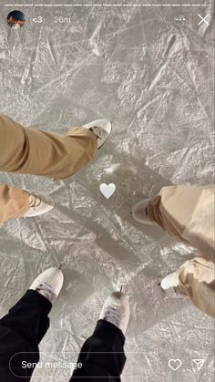 three people standing on an ice rink looking down at the ground with their feet in the air