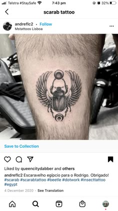 a tattoo on the leg of a man with wings and a beetle in it's center