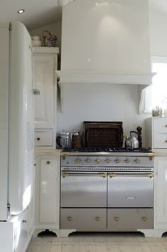 a white kitchen with an oven and refrigerator