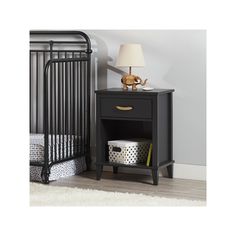 a black night stand next to a baby crib