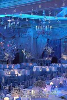 a banquet room with blue lighting and chandeliers