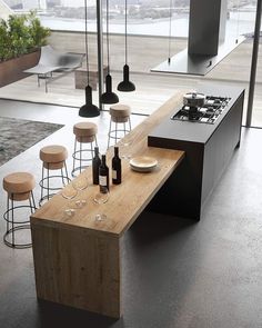 a modern kitchen with an island table and stools in front of the countertop