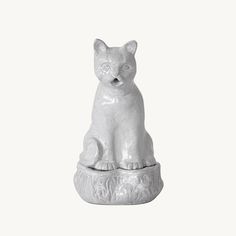 a white cat statue sitting on top of a table