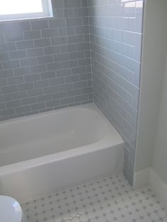 a white bath tub sitting next to a toilet