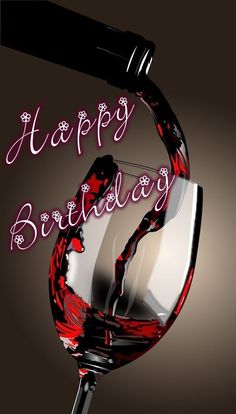 a glass of red wine with the words happy birthday written on it in pink lettering