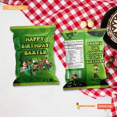 a bag of happy birthday baxter next to a cupcake and some candies on a checkered table cloth