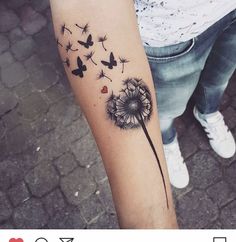 a woman's arm with a dandelion tattoo on it and butterflies flying around