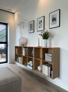 a living room filled with furniture and pictures on the wall next to a large window