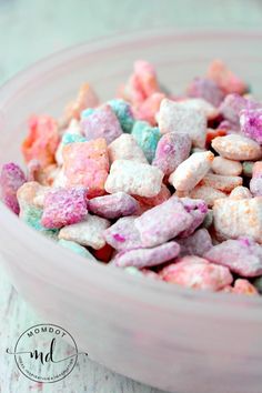 a bowl filled with pink, blue and green marshmallows on top of a table