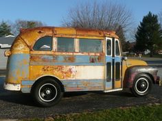 an old rusted out bus parked on the side of the road in front of a house