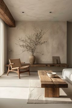 a living room with a couch, coffee table and vase on the wall next to it