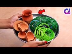 two hands holding a bowl filled with different colored clay pieces