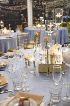 an image of a table setting with flowers in vases and candles on the tables