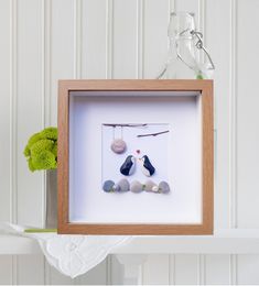 there is a frame with some rocks in it and a stuffed animal next to it